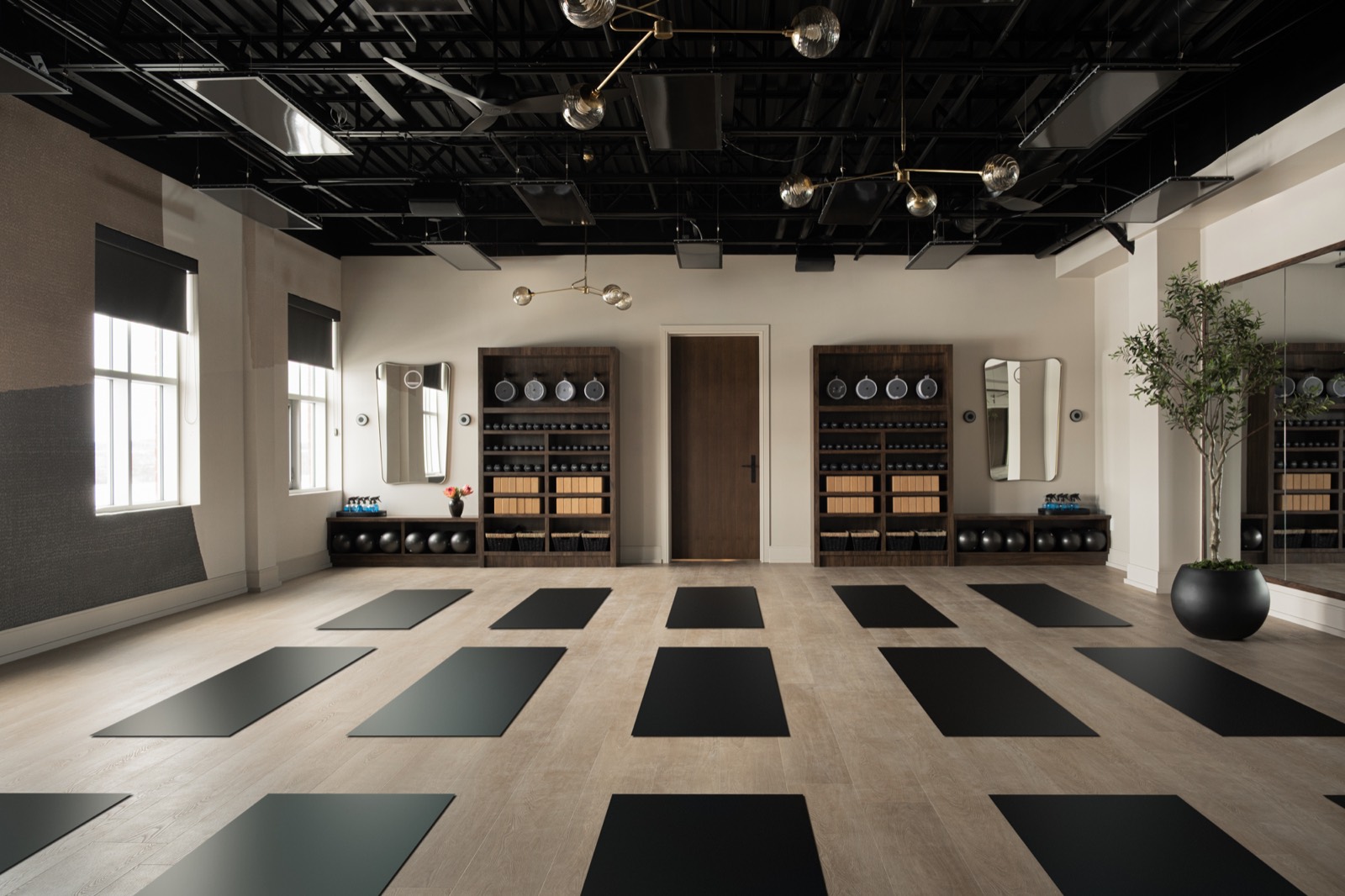 The Forma mat studio with mats laid out, prop shelving, and an olive tree