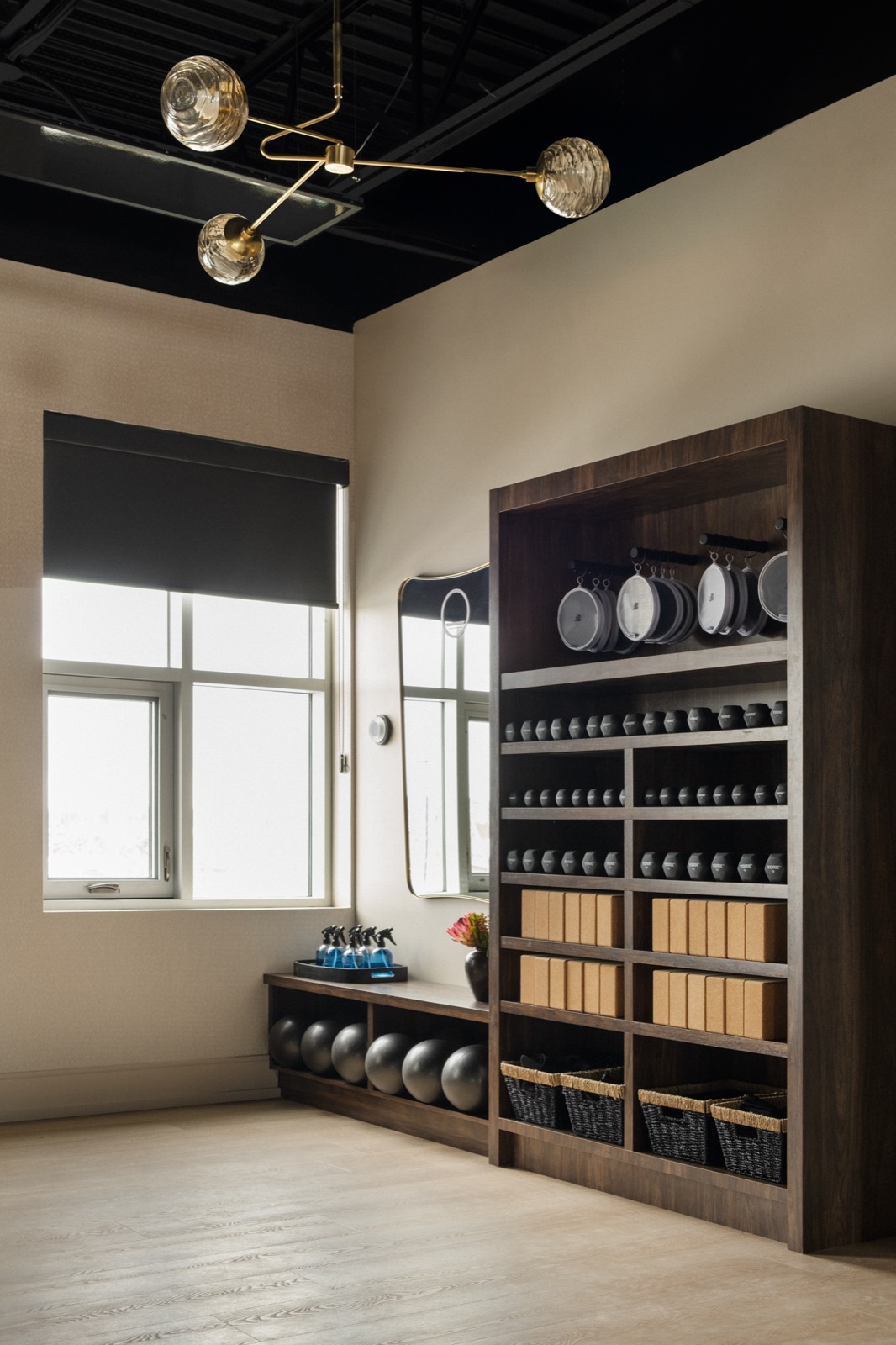 Prop shelving in the mat studio with rings, balls, and blocks beside a window