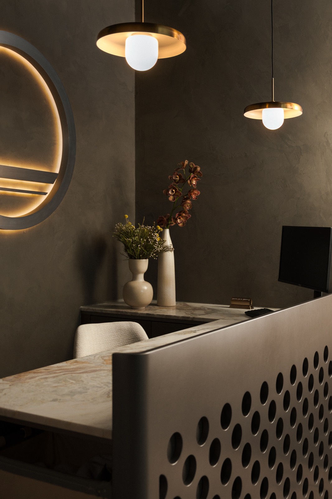 Pendant lights and the backlit Forma emblem above the front desk