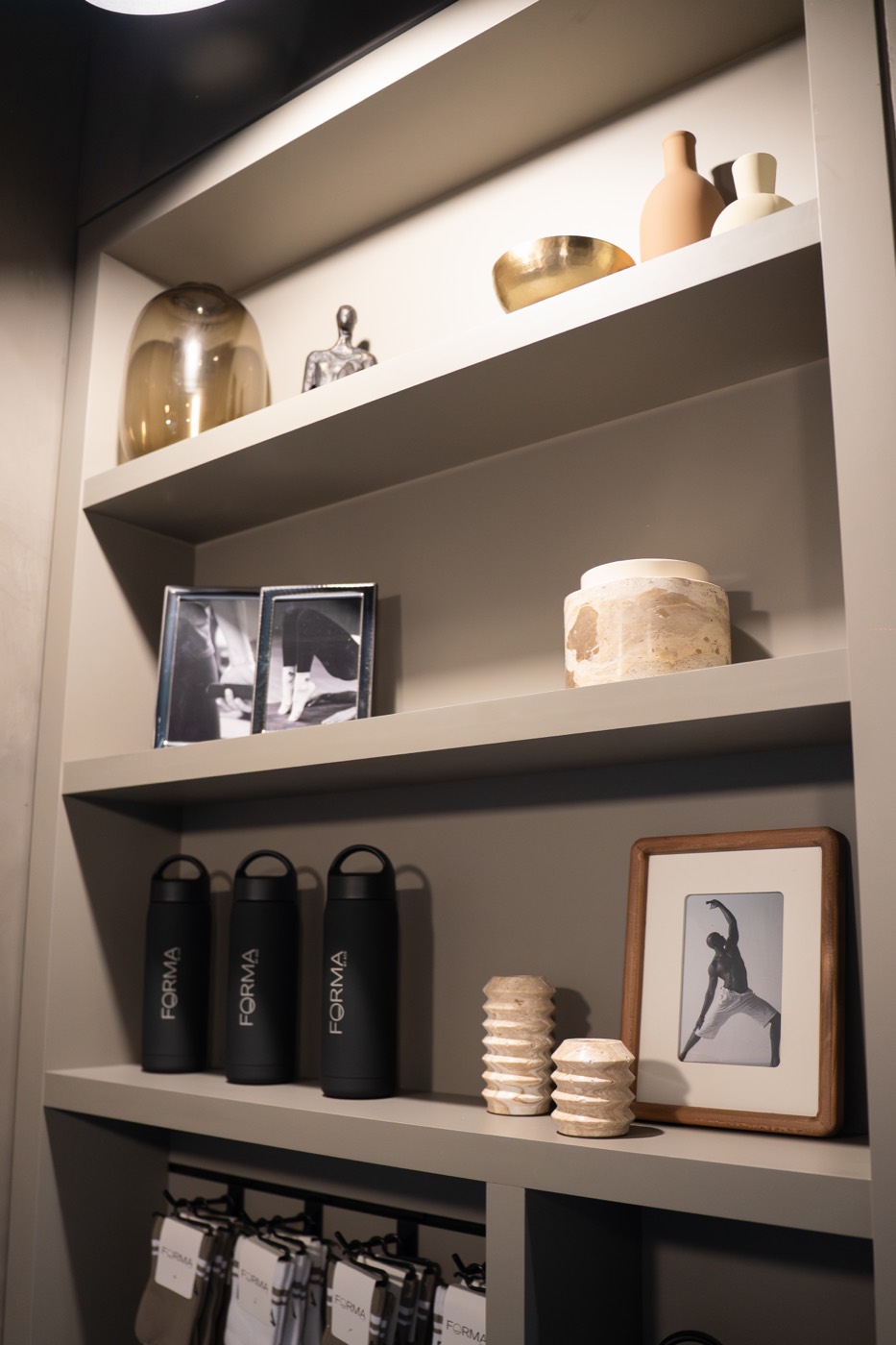 Forma retail shelf with branded water bottles, grip socks, and decor